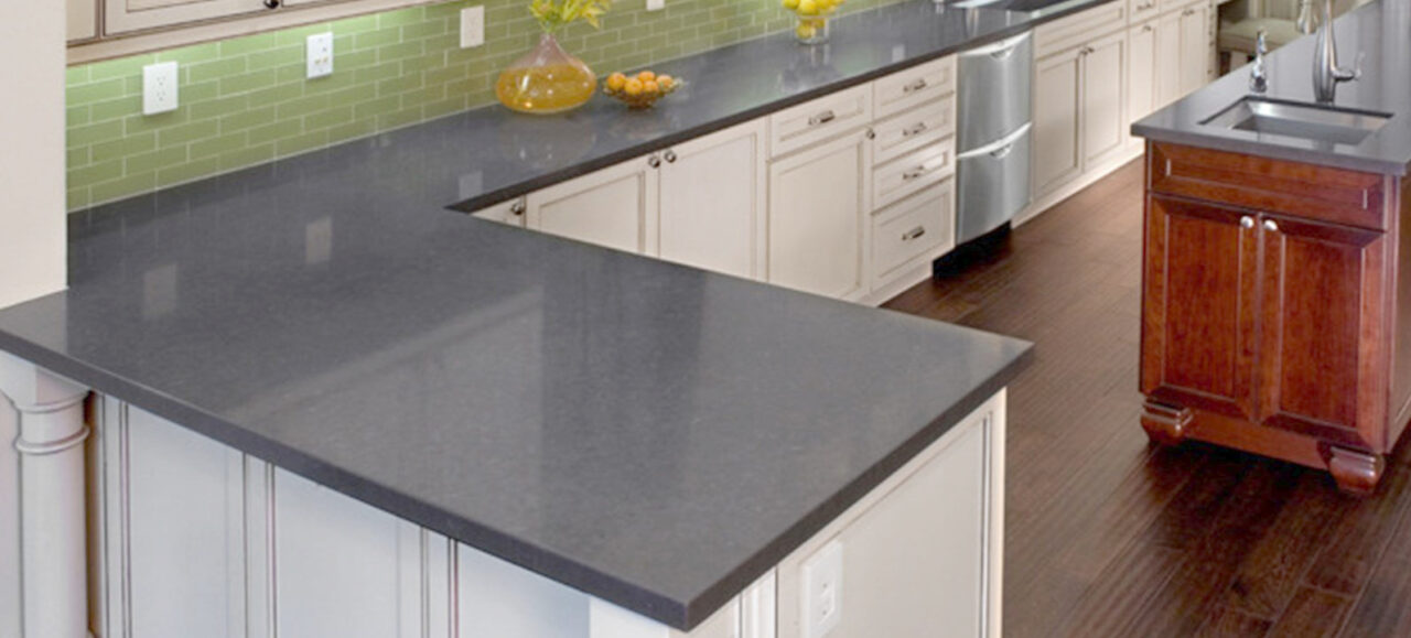 White kitchen with Caesarstone® worktop in Raven with green tile splashback