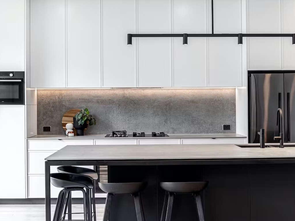 White kitchen with grey Dekton® Kreta worktops and glass splashback