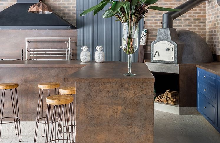 Contemporary kitchen design showing a kitchen island covered in a copper-coloured worktop called Neolith® Iron Corten