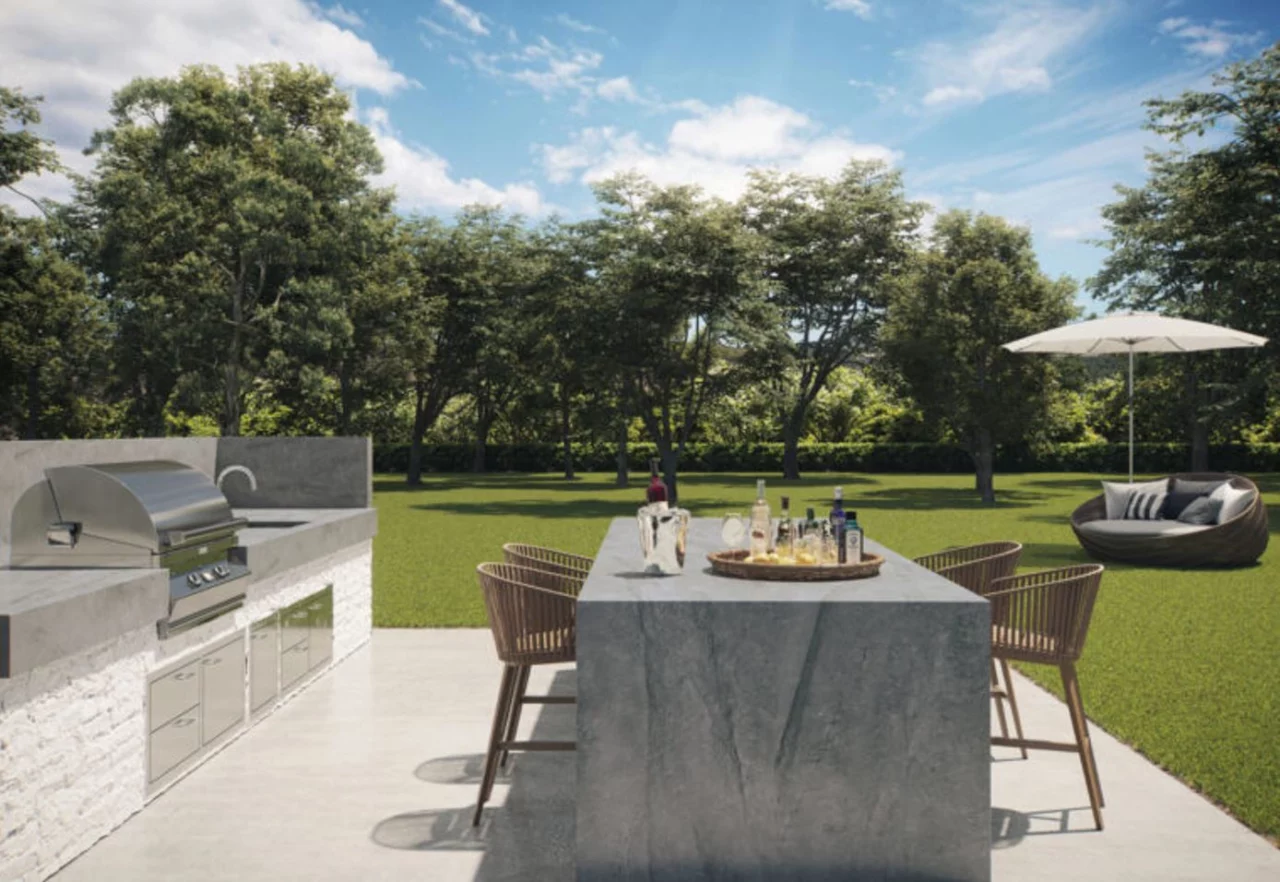Outdoor kitchen and table with grey Caesarstone® Porcelain outdoor kitchen worktops in Monumental.