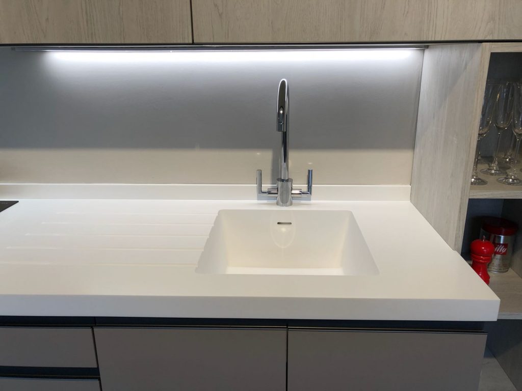 White kitchen worktop with a white sink and drainer grooves